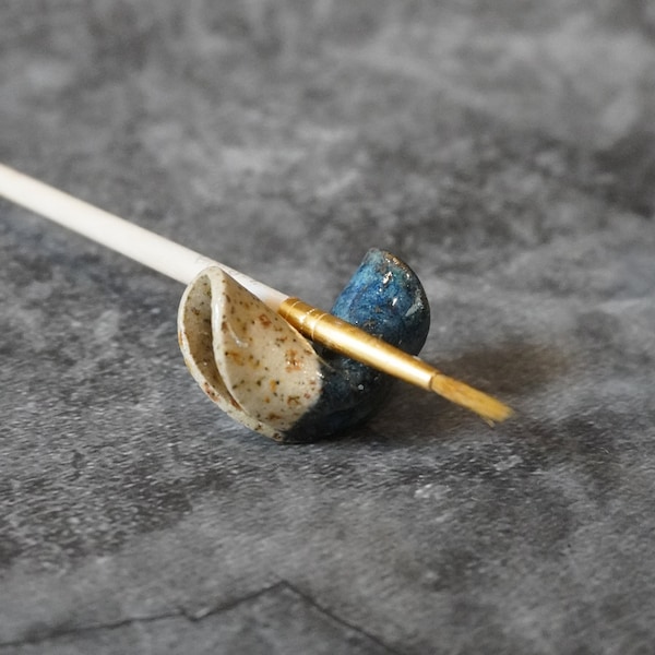 Descanso para pincéis em forma de biscoito da sorte, feito à mão em cerâmica, acessório artístico azul salpicado.