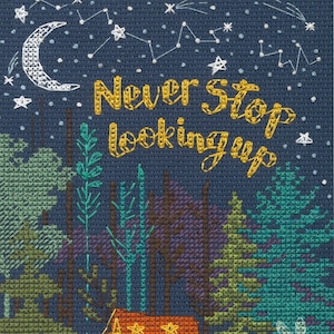 May include: Cross-stitch pattern featuring a tent in a forest with a starry night sky. The text "Never Stop Looking Up" is stitched in yellow thread.