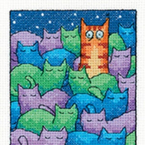 May include: A cross-stitch pattern featuring a group of sleeping cats with a single orange cat awake, with the text "THE INSOMNIAC" at the bottom.