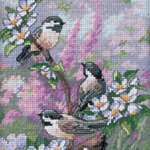 May include: Three small birds perched on a branch with white blossoms. The birds are black and white with brown accents. The background is a soft, blurred, pastel pink and blue.
