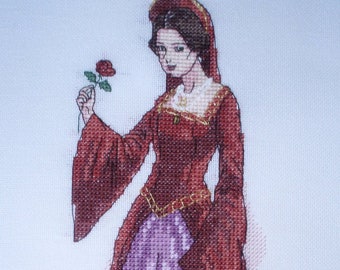 May include: A cross-stitch embroidery of a woman in a red dress and a purple skirt, holding a red rose. She is wearing a gold crown and a white collar.