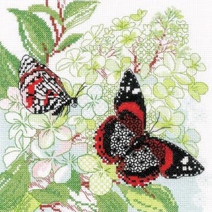 May include: A cross-stitch embroidery pattern featuring two butterflies with black, white, and red wings resting on a cluster of light green and white hydrangea flowers with green leaves, rendered in a detailed grid-like needlepoint stitch style.