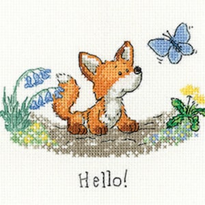 May include: Cross-stitch design featuring a cartoon fox with orange fur, looking up at a blue butterfly. The fox is surrounded by bluebells, dandelions, and the word "Hello!" in black text.