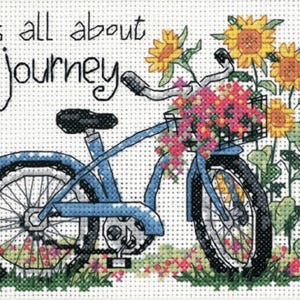 May include: A blue bicycle with a basket full of colourful flowers. The bicycle has a white tyre and a black tyre. The text "It's all about the journey" is written in black on a white background.