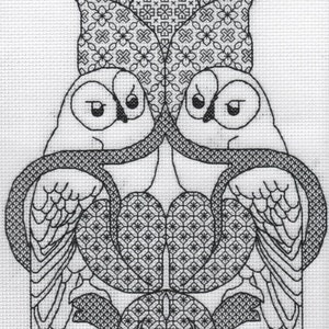 May include: Black and white cross-stitch pattern of two owls facing each other with their wings spread out. The owls are surrounded by a geometric pattern.