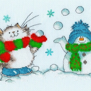 May include: A white cat wearing a red and green scarf throws a snowball at a snowman wearing a blue hat and green scarf. The snowman is throwing snowballs in the air.