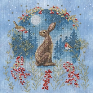 May include: Cross-stitch design depicting a brown hare, two birds, and red berries on a blue backdrop. A full moon and a wreath of berries and leaves frame a forest scene. The design has a winter or festive theme.
