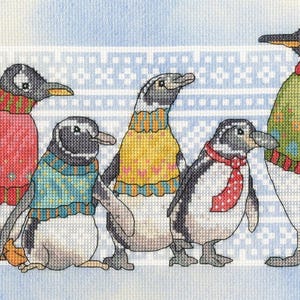 May include: Cross-stitch design showing five penguins wearing sweaters and standing against a patterned backdrop. The penguins are dressed in red, blue, yellow, and green sweaters, and one has a red polka-dot scarf.