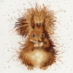 May include: A brown and white cross-stitch embroidery of a squirrel with a fluffy tail and big eyes. The squirrel is sitting on a white background with brown speckles.
