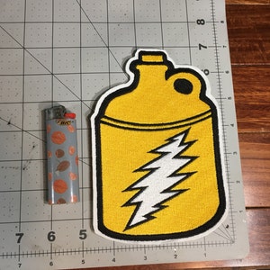 May include: Yellow fabric patch with a black outline, depicting a yellow canteen with a white lightning bolt design. The patch is approximately 5 inches tall.