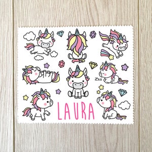May include: White rectangular sticker with cartoon unicorns with rainbow manes and tails, surrounded by stars, diamonds, and clouds. The name "LAURA" is printed in pink. The sticker has a scalloped edge.