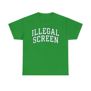 May include: A bright green t-shirt with the words "ILLEGAL SCREEN" printed in white, arched lettering. The shirt is a crew neck style and appears to be made of a soft material. The text is centered on the front of the shirt.