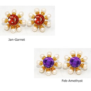 Peut inclure: Deux paires de boucles d'oreilles en or avec un motif floral. La premi&egrave;re paire pr&eacute;sente une pierre pr&eacute;cieuse rouge, et la deuxi&egrave;me paire pr&eacute;sente une pierre pr&eacute;cieuse violette. Les boucles d'oreilles sont entour&eacute;es de perles blanches.