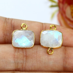 May include: Two gold-toned pendant charms with a rectangular moonstone gemstone. The charms have a loop on each side for attaching to a necklace or bracelet.