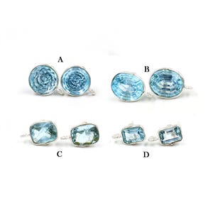 May include: Four pairs of earrings featuring different styles of blue topaz gemstones. The earrings are labelled A, B, C, and D.