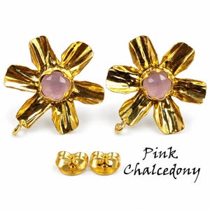 May include: A pair of gold-toned flower-shaped earrings with a central faceted pink chalcedony stone, accompanied by two matching gold-toned earring backs. The text "Pink Chalcedony" is printed in black script on the lower right side of the image.