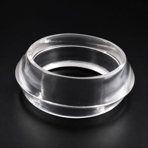 May include: A clear, transparent, circular bangle bracelet with a smooth, polished surface. The bracelet features a wide, slightly tapered band design with a rounded outer edge and a hollow center, creating a simple, uniform, and reflective appearance.
