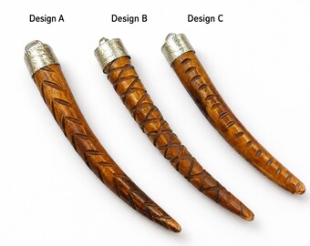 May include: Three curved, horn-shaped pendants made of brown wood with silver-toned metal caps. Each piece features distinct carved patterns: Design A has a chevron motif, Design B has a cross-hatch pattern, and Design C has horizontal grooves.