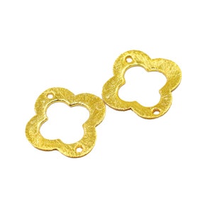 May include: Two gold-colored metal flower-shaped charms with a hole in the center of each. The charms have a textured surface.