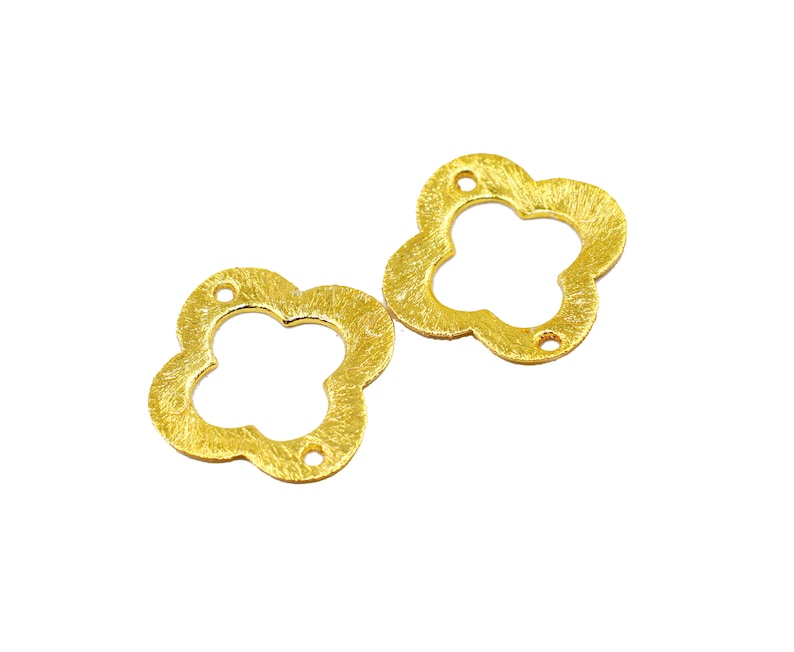 May include: Two gold-colored metal flower-shaped charms with a hole in the center of each. The charms have a textured surface.