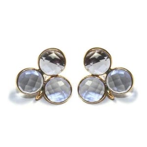 May include: A pair of gold tone earrings with three clear faceted stones each. The stones are arranged in a clover shape.