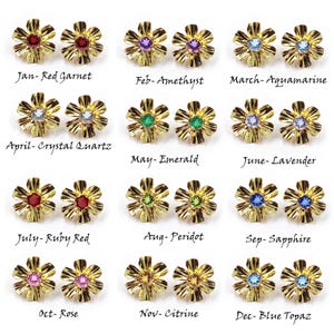May include: Twelve pairs of gold-tone flower-shaped stud earrings, each featuring a different colored gemstone representing birthstones from January to December, labeled with month names and stone types including garnet, amethyst, aquamarine, and topaz.