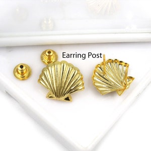 May include: Gold-colored seashell-shaped earring posts and backs. The earrings have a detailed, ridged design, and the backs are simple, round, and gold. The text "Earring Post" is visible in the image.