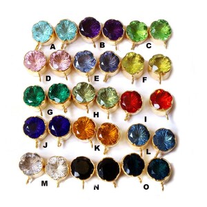 May include: Assortment of 15 pairs of glass gemstone beads with gold-tone metal caps and loops. The beads are in various colors, including blue, green, red, orange, purple, and black.