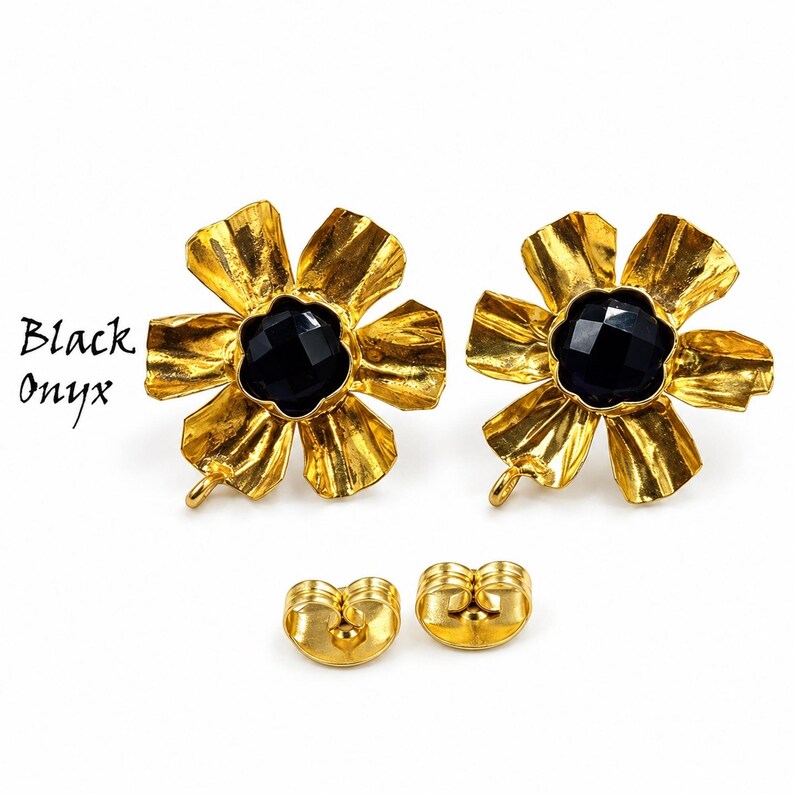 May include: A pair of gold-toned flower-shaped earrings featuring a faceted black onyx center stone. The petals have a textured, crinkled finish. Each earring includes a small loop at the bottom and a matching gold-toned butterfly earring back.