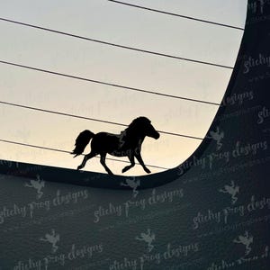 May include: A black silhouette of a horse in motion, set against a backdrop of horizontal lines and a gradient sky. The horse is depicted with a flowing mane and tail, suggesting movement. The image has a minimalist design.