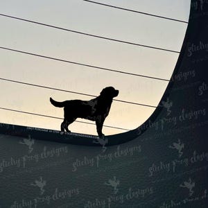 May include: A black silhouette of a dog standing against a backdrop of horizontal lines and a gradient sky. The dog is facing left, with its tail slightly curved. The image has a minimalist design.