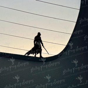 May include: A black silhouette of a figure in a hooded cloak, holding a sword, stands on a curved surface. The background features a gradient sky with horizontal lines. The image has a dramatic, mysterious feel.