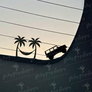 May include: Black silhouette of a jeep climbing a hill, with palm trees and a hammock forming a smiling face. The background shows a gradient sky. The image has the text "Sticky Frog Designs" and "www.StickyFrogDesigns.com".