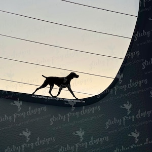 May include: Black silhouette of a dog walking across a curved surface, set against a light background with horizontal lines. The text "ONLY PURCHASE ON ETSY @ STICKYFROGDESIGNS.COM" is visible.