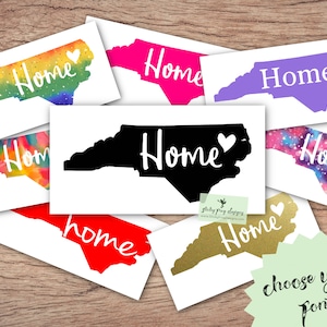 May include: A collection of North Carolina state outline decals with the word "Home" in various fonts and colors. The decals are on white backgrounds and are arranged in a collage. The text "choose your font" is written in cursive at the bottom of the image.