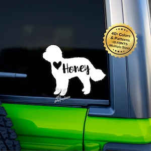 May include: White silhouette of a dog with the name "Honey" and a heart next to it. The decal is on a black background. The image also includes a gold starburst sticker with the text "40+ Colors & Patterns -18 Fonts -Multiple Sizes".