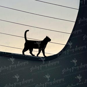 May include: A black silhouette of a cat walking along a curved surface, set against a backdrop of horizontal lines and a gradient sky. The cat's tail is curved upwards. The image has a minimalist design.