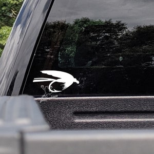 May include: White silhouette of a fly fishing lure with a frog on a black car window.