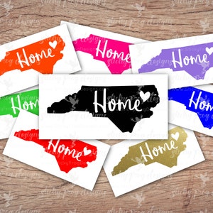 May include: A set of ten North Carolina state outline decals in various colors, including red, green, blue, purple, black, and gold. Each decal features the word "Home" in white with a small heart next to it.