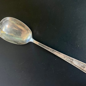 May include: A silver sugar spoon with an ornate design on the handle.