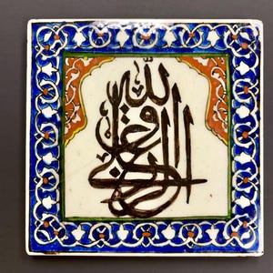 Peut inclure: Carreau de céramique carré avec calligraphie arabe noire sur fond blanc. Le carreau est encadré d'une bordure florale bleue et blanche, avec des accents orange et rouges. Pièce décorative.