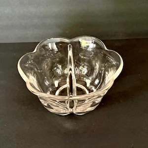 Könnte beinhalten: Klarer, geteilter Servierteller aus Glas mit gewelltem Rand. Die Schale hat eine zentrale Trennwand und ein dekoratives Muster auf der Basis. Das transparente Glas ermöglicht eine klare Sicht auf den Inhalt.