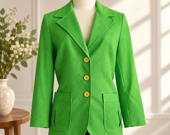 May include: A vibrant lime green blazer featuring a notched lapel, long sleeves, and three yellow buttons down the front. The garment includes two large patch pockets on the lower front section, each with a vertical pleat detail at the centre.