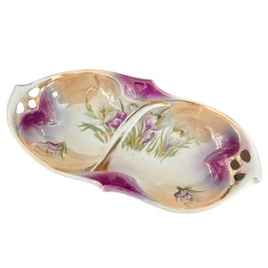 May include: A white porcelain serving dish with a divided centre and a handle. The dish is decorated with a floral pattern of purple and white crocuses and has a gold trim.