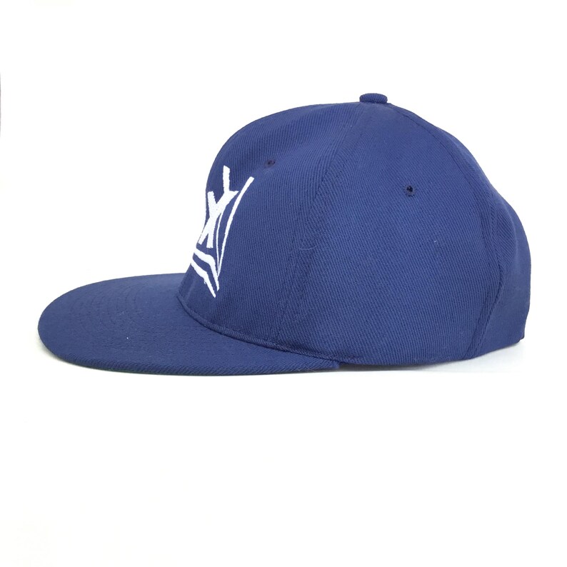 May include: A navy blue baseball cap with a flat brim. The cap features a white embroidered design on the front. The hat is made of a sturdy fabric and has a structured fit.