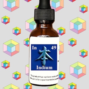 May include: A brown glass bottle with a black dropper top. The label is white with blue text that reads "In 49 Indium". The label also includes a blue and silver symbol. The background is a pattern of colorful cubes.