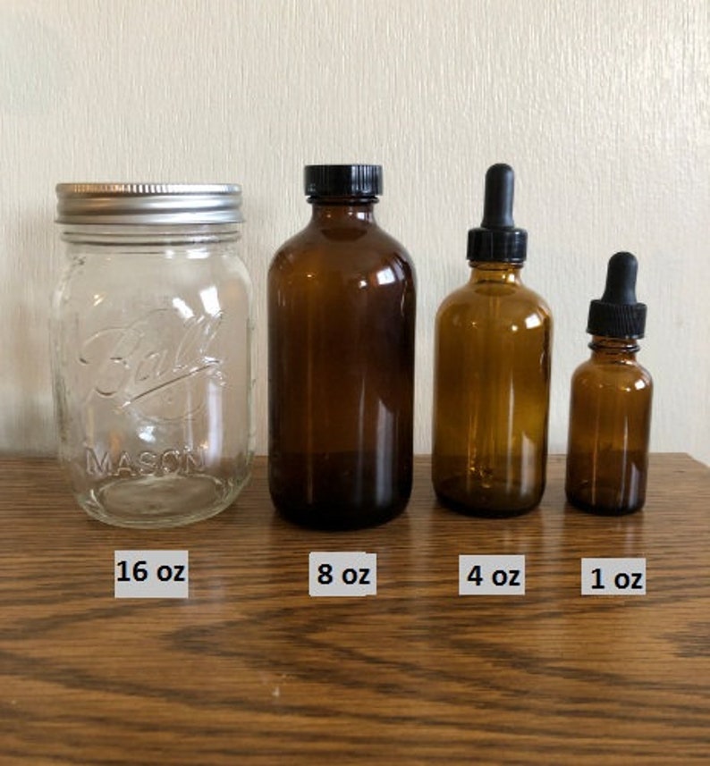May include: Four glass bottles of different sizes with black lids. The bottles are labeled with their volume: 16 oz, 8 oz, 4 oz, and 1 oz.