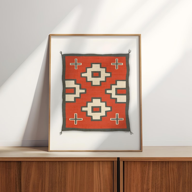 May include: A framed print of a red, white, and black geometric pattern. The pattern is reminiscent of Native American rug designs.