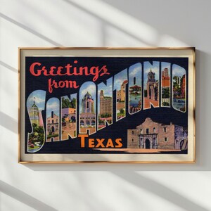 May include: Framed vintage postcard print with the text "Greetings from San Antonio Texas." The postcard features a collage of San Antonio landmarks and buildings, with a dark blue background and a gold frame.