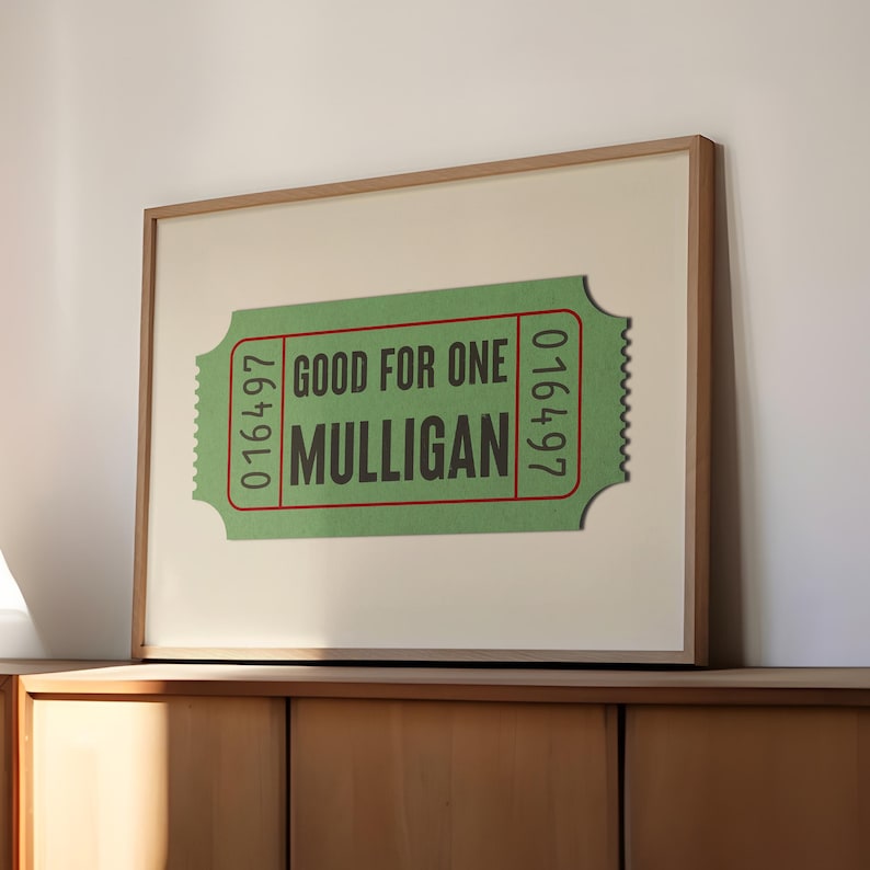 Op de afbeelding: Een ingelijst afdruk van een groen kaartje met de tekst "GOOD FOR ONE MULLIGAN" en de nummers "016497" aan beide kanten.